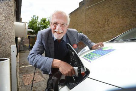 Oxford city councillor John Tanner plugging a charger into one of the council's own vehicles